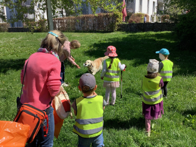 Kinder der Kita Aufwind beobachten die Golden-Retriever-Hündin Malka beim Müllsammeln während der Dreck-weg-Aktion.