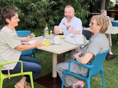 Besucherinnen sitzen im Garten des AWO Seniorenzentrums Berghausen zusammen und tauschen sich beim Tag der offenen Tür aus.