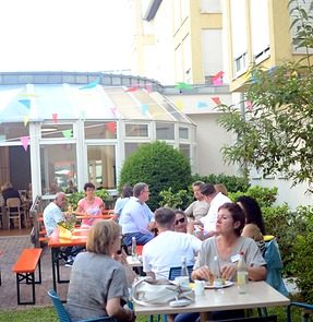 Besucherinnen genießen den Tag der offenen Tür im Garten des AWO Seniorenzentrums Berghausen und kommen miteinander ins Gespräch.*