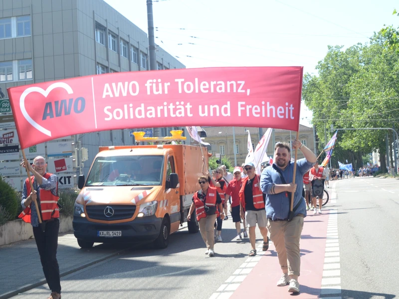 Zwei Teilnehmer tragen das AWO-Banner „Für Toleranz, Solidarität und Freiheit“ an der Spitze des Demonstrationszuges.