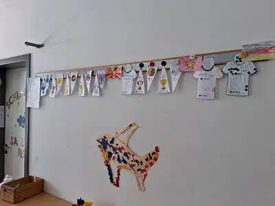 Bunte Wimpel mit Länderflaggen hängen an der Decke unserer Kita les explorateurs.