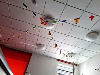 Von Kindern gestaltete Fußballtrikots und Länder-Wimpel hängen an einer Wand in unserer Kita les explorateurs.