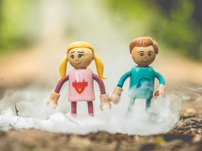 Zwei kleine Spielfiguren stehen in künstlichem Nebel auf dem Waldboden.