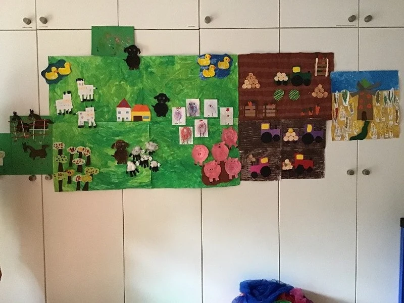 Großes Gemeinschaftsbild zum Bauernhofprojekt mit Schafen, Schweinen, Kühen, Feldern und Fahrzeugen.