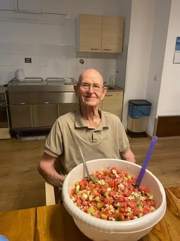 Bewohner des Hauses am Blumentor hält eine große Schüssel mit frisch zubereitetem Melonensalat.