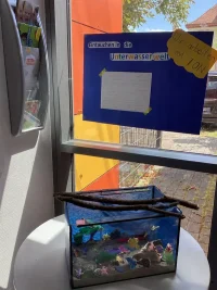 Mehrere kleine Meerestiere aus bemalter Modelliermasse liegen auf einem Tisch.