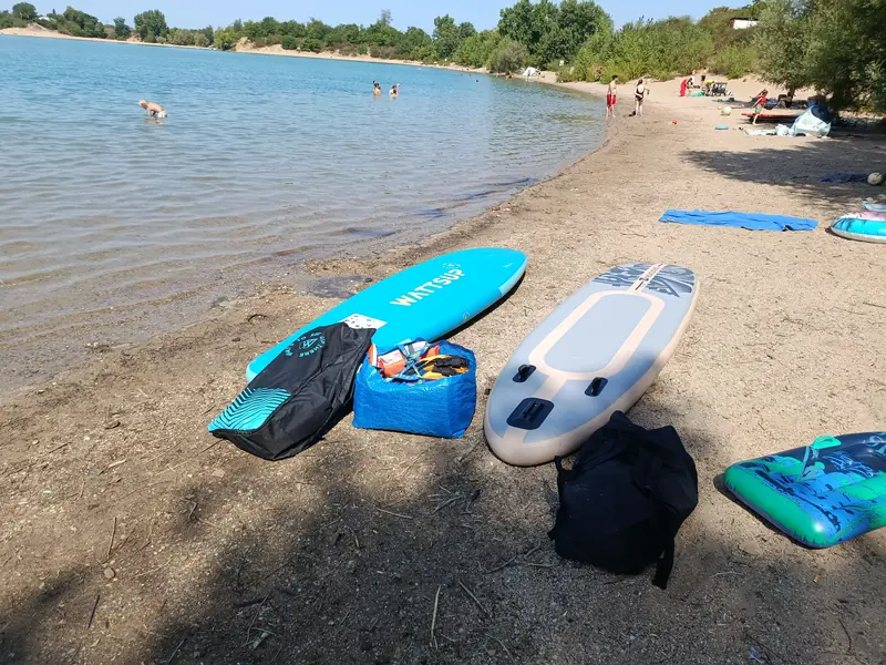 Mehrere Stand-up-Paddleboards und Ausrüstung liegen am Ufer des Epplesees