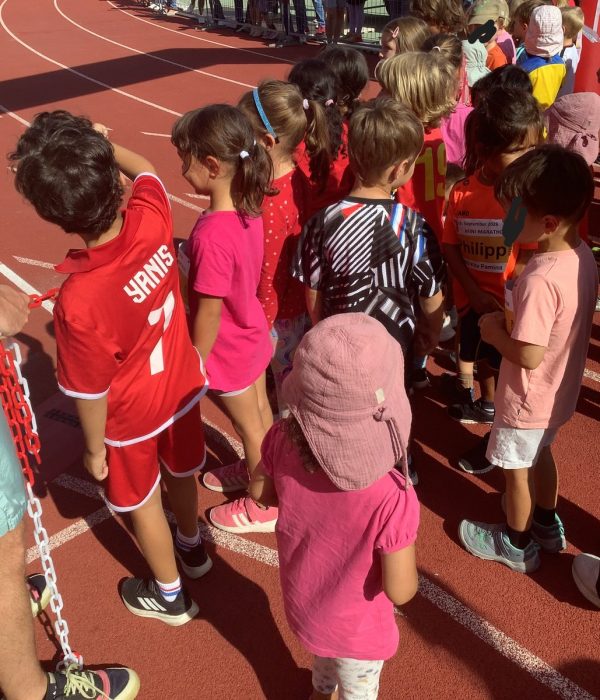 Kinder der Kita Pamina gehen beim Bambini-Marathon nebeneinander über das Veranstaltungsgelände.